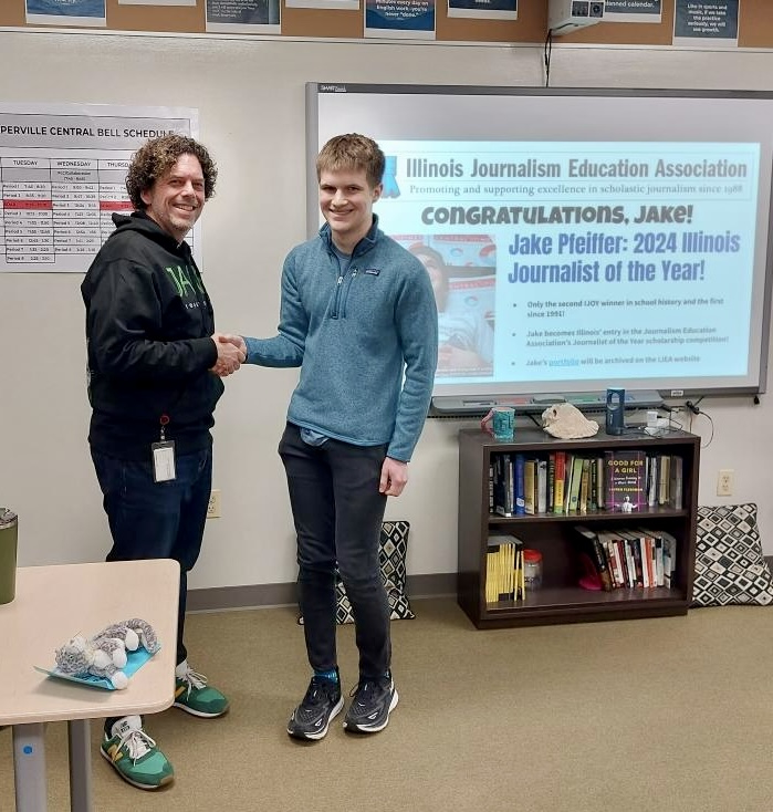 Naperville Central newspaper adviser Keith Carlson congratulates senior Jake Pfeiffer on winning the 2024 Illinois Journalist of the Year Award. Jake is editor-in-chief of both the print and online versions of the schools newspaper, Central Times. (Photo courtesy of Keith Carlson)